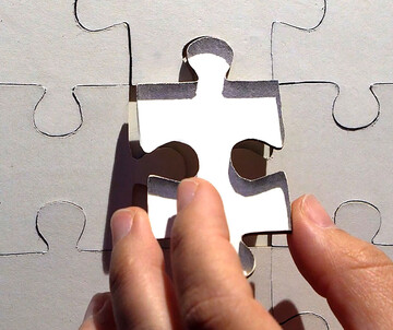 Missing Piece Eine Hand setzt ein fehlendes Puzzleteil ein