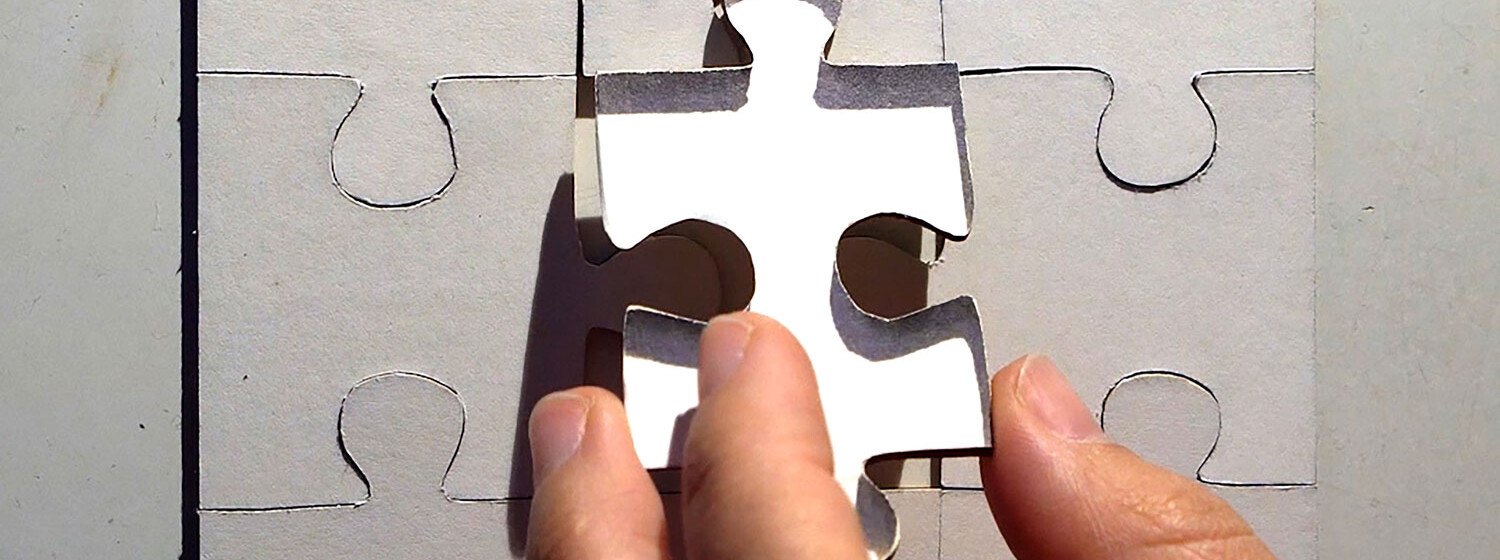 Missing Piece Eine Hand setzt ein fehlendes Puzzleteil ein