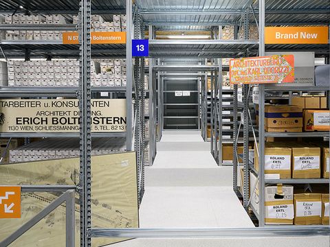 Es ist ein langer Gang mit gefüllten Regalen zu sehen.