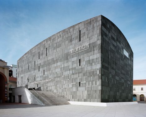 Cubic museum with a facade made of rectangular stone slabs and the inscription 'mumok'