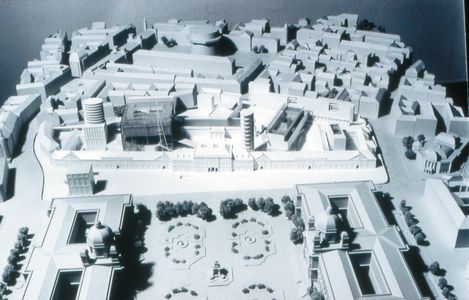 White architectural model of an urban area with buildings, streets, and a park with symmetrical paths and trees