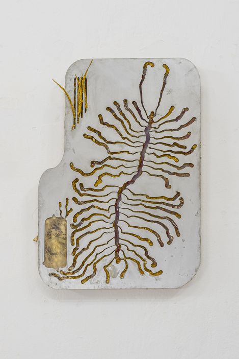 Rectangular object with rounded corners featuring gold-colored branching circuit paths on a white background mounted on a wall.