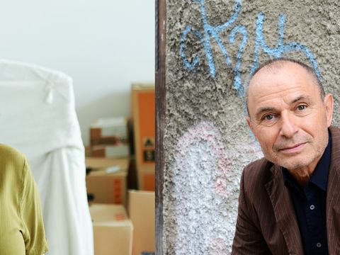 Two people, one standing in a room with boxes, the other leaning against a graffiti-covered wall next to a window with peeling paint.