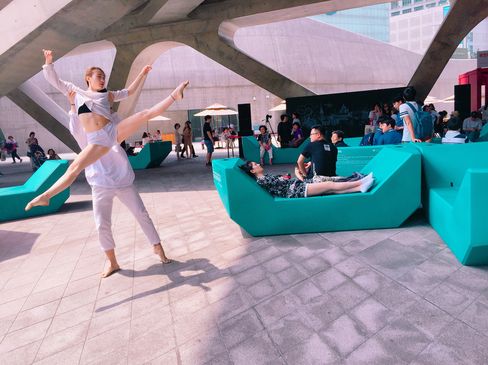 Eine Tänzerin führt eine Performance zwischen Enzi-Sitzmöbeln aus, während Menschen im Hintergrund zuschauen.