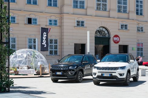 Jeep Promotion am MQ Vorplatz. Zwei große Autos stehen auf dem Pflaster. Daneben eine Sitzgelegenheit und eine Jeep Fahne.