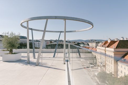 Dachterrasse mit großem, rundem Metallgestell und Glasgeländer mit Blick auf umliegende Gebäude auf der Libelle im MuseumsQuartier
