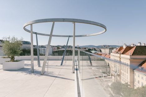 Dachterrasse mit großem, rundem Metallgestell und Glasgeländer mit Blick auf umliegende Gebäude auf der Libelle im MuseumsQuartier