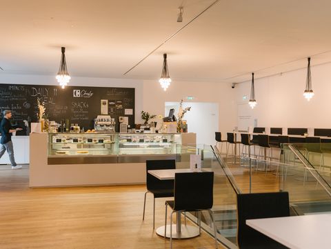 Großzügiger Innenraum des mumok Cafés mit Sitzbereichen, Theke und moderner Beleuchtung.