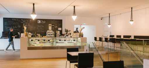 Spacious interior of the mumok café with seating areas, counter and modern lighting.