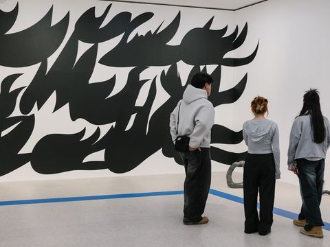 People are looking at a large-scale black-and-white mural at mumok.