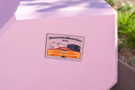 Detailaufnahme eines rosa Enzis mit MuseumsQuartier Wien Sticker auf der Oberfläche.