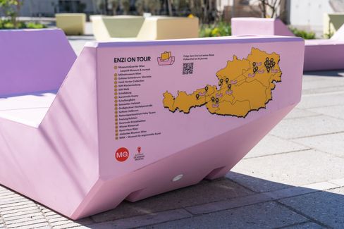 Rosa Enzi mit „Enzi on Tour“-Karte von Österreich und markierten Stationen im MuseumsQuartier Hof.