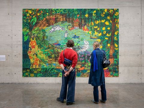 Zwei Personen betrachten ein großformatiges Kunstwerk von Rini Mitria.