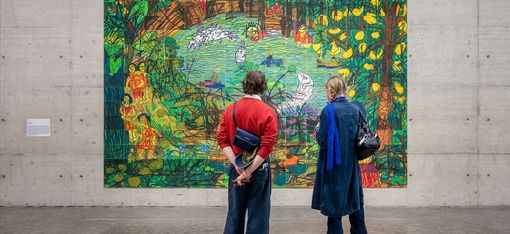 Zwei Personen betrachten ein großformatiges Kunstwerk von Rini Mitria.