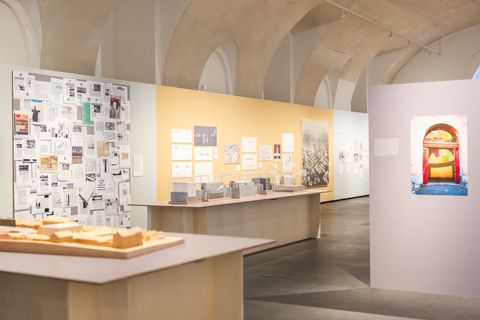 Ausstellungsraum mit Modellen, Wandtafeln und Fotografien in einem Raum mit gewölbter Decke