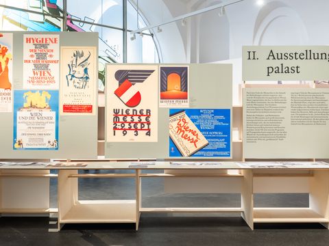 Ausstellungstafeln mit historischen Plakaten und Texten in einem hellen Ausstellungsraum mit hohen Fenstern