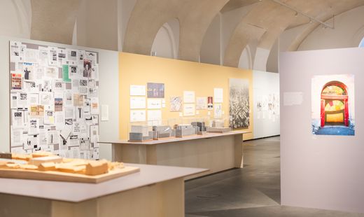 Ausstellungsraum mit Modellen, Wandtafeln und Fotografien in einem Raum mit gewölbter Decke