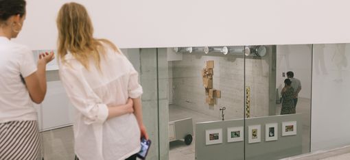 Personen stehen vor einem Kunstwerk und betrachten es.