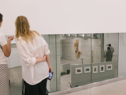 Personen stehen vor einem Kunstwerk und betrachten es.