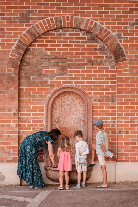 Eine Familie untersucht gemeinsam einen historischen Brunnen im MuseumsQuartier als Station des MQ-Rätselparcours.