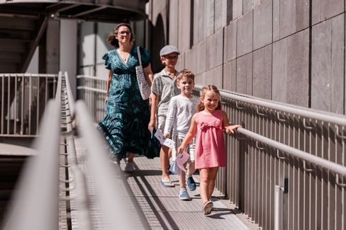 Eine Familie geht mit den Unterlagen des MQ-Rätselparcours über eine Rampe im MuseumsQuartier und erkundet das Gelände.