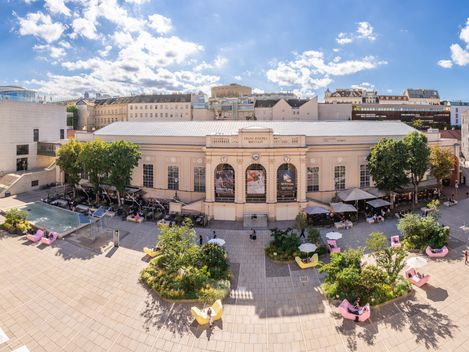 Panoramablick über den begrünten Haupthof des MuseumsQuartier Wien mit Leopold Museum, Halle E+G, mumok, Gastronomie und MQ Möbeln.