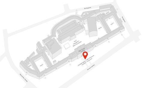 Black-and-white 3D view of a building complex with a marked location at the main entrance forecourt.