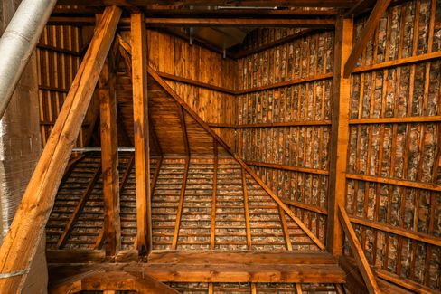 Close-up of a roof structure with curved wooden beams and tightly arranged bricks between the supports.