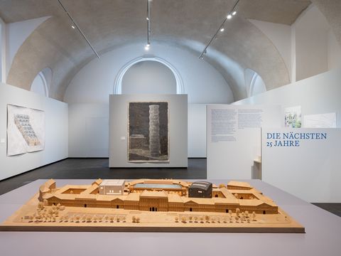 Ausstellungsansicht von „Vision und Widerstand“ im MQ Freiraum mit einem Architekturmodell des MuseumsQuartier Wien und historischen Entwürfen zur Entwicklung des Areals.