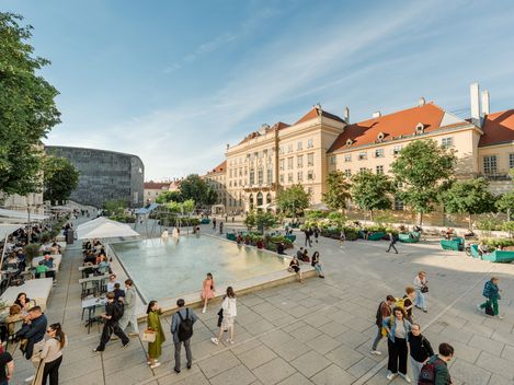 Menschen im MQ Haupthof an einem sonnigen Tag