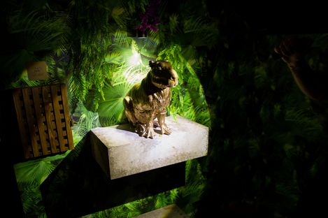 Golden animal figure on a pedestal, surrounded by dense green jungle scenery and focused lighting.