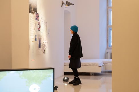 Visitor viewing a documentary wall installation with texts, maps and photographs at an exhibition in MuseumsQuartier Vienna