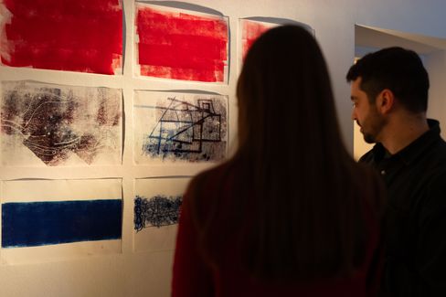 Two visitors viewing abstract prints and drawings displayed on a gallery wall at MuseumsQuartier Vienna