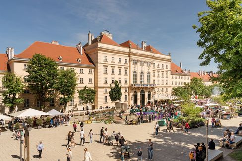 The bustling MQ main courtyard during the KinderKulturParcours 2025 on a sunny day.