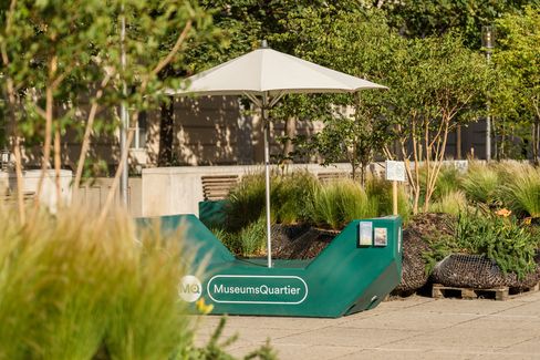 Green Enzi with sun umbrella and MuseumsQuartier lettering, surrounded by greenery