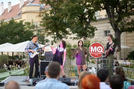MQ Tunes, Band: Low Life Rich Kids. Vier Personen singen auf einer Bühne im MQ Innenhof.