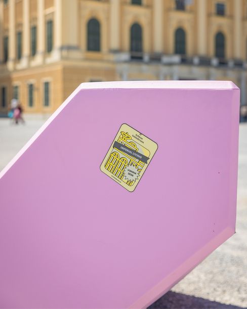 Detailaufnahme eines rosa Enzi-Sitzmöbels mit „Imperial Living Vienna 2026“-Sticker vor Schloss Schönbrunn.