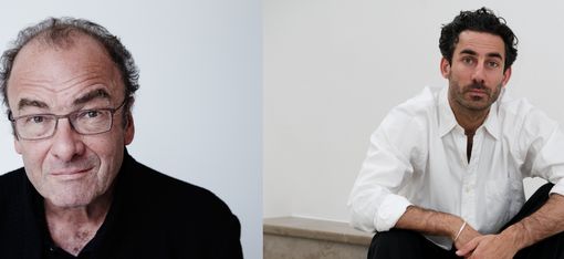 Two men with dark hair sitting against a light background, the left wearing a black shirt and the right wearing a white shirt.