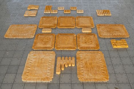 Several rectangular and square wooden plates with serrated edges and various patterns arranged on a gray grid surface.