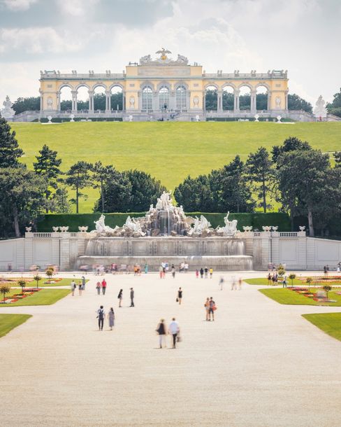 Blick auf die Gloriette und den Neptunbrunnen im Schlosspark Schönbrunn in Wien.