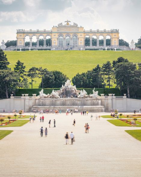 Blick auf die Gloriette und den Neptunbrunnen im Schlosspark Schönbrunn in Wien.