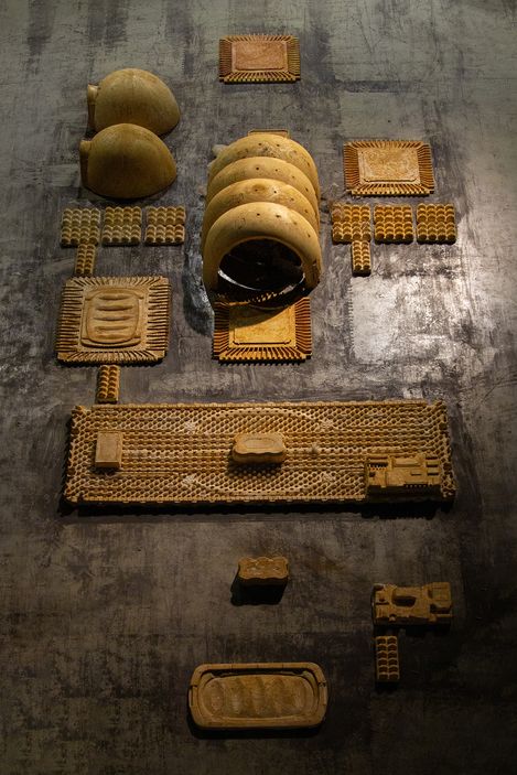 Several rectangular and semicircular clay objects with patterns arranged on a dark surface.