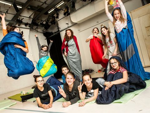 Children are on stage at DSCHUNGEL WIEN with their sleeping bags.