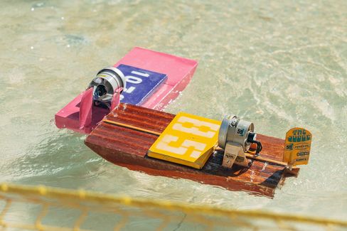 Close-up of handcrafted model boats floating in the water basin at the Aquadrome in MuseumsQuartier Vienna.