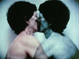 Two people kissing in a double exposure with slightly blurred outlines.