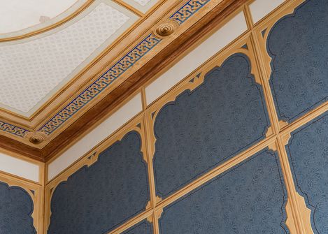 Ceiling and upper wall of a room with baroque style elements and decorative blue wall panels in the Baroque Suite at MuseumsQuartier Vienna.