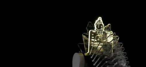 Leuchtende, transparente Acrylfiguren mit Comiczeichnungen auf schwarzem Hintergrund