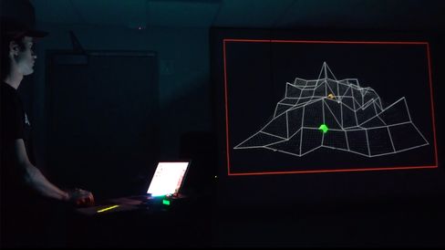 Person standing in front of a screen displaying a 3D wireframe model in a dark room.