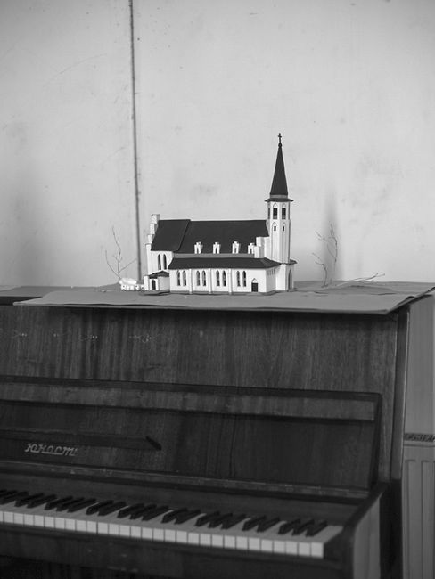Model of a church with a tower on a piano.