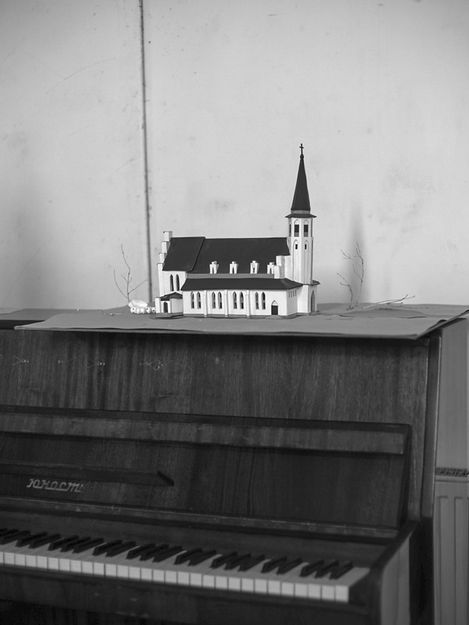 Model of a church with a tower on a piano.